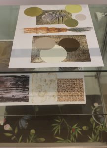 Display case with some paper art works inside.