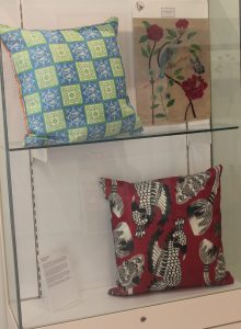 Display case with cushions in bright coloured fabric.
